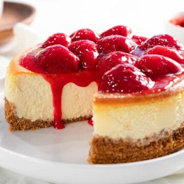 Strawberry cheesecake with strawberry topping flowing down the sides.