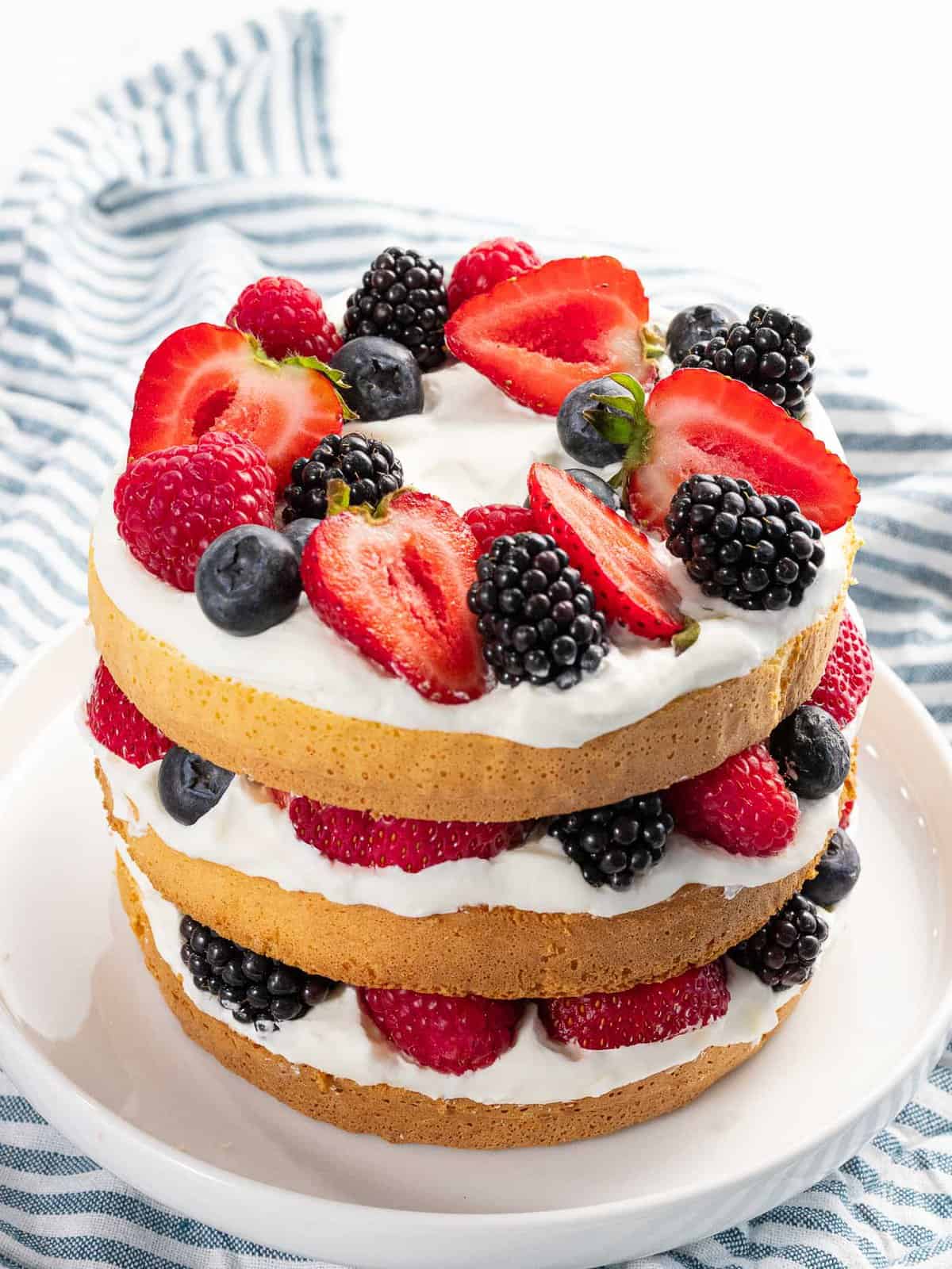 Summer berry cake made with mixed berries and whipped cream.