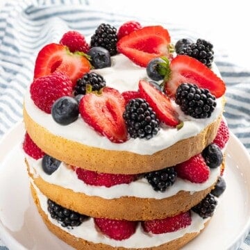 Berry cake with mixed berries, whipped cream, and layered cake.