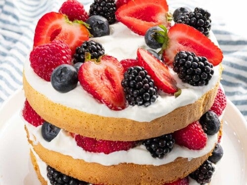 Berry cake with mixed berries, whipped cream, and layered cake.