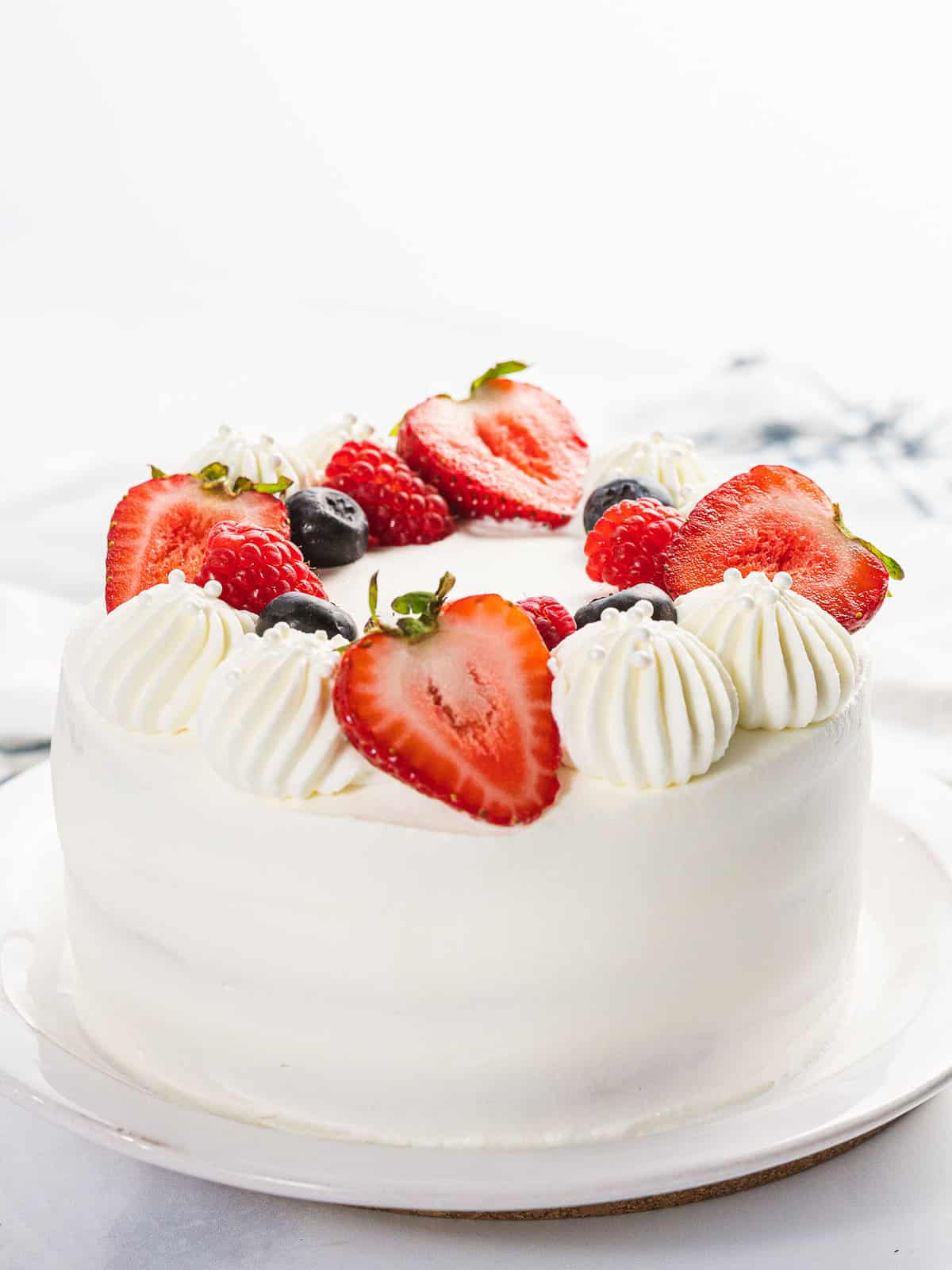 Fluffy berry Chantilly cake with strawberries, blueberries, and Chantilly cream.