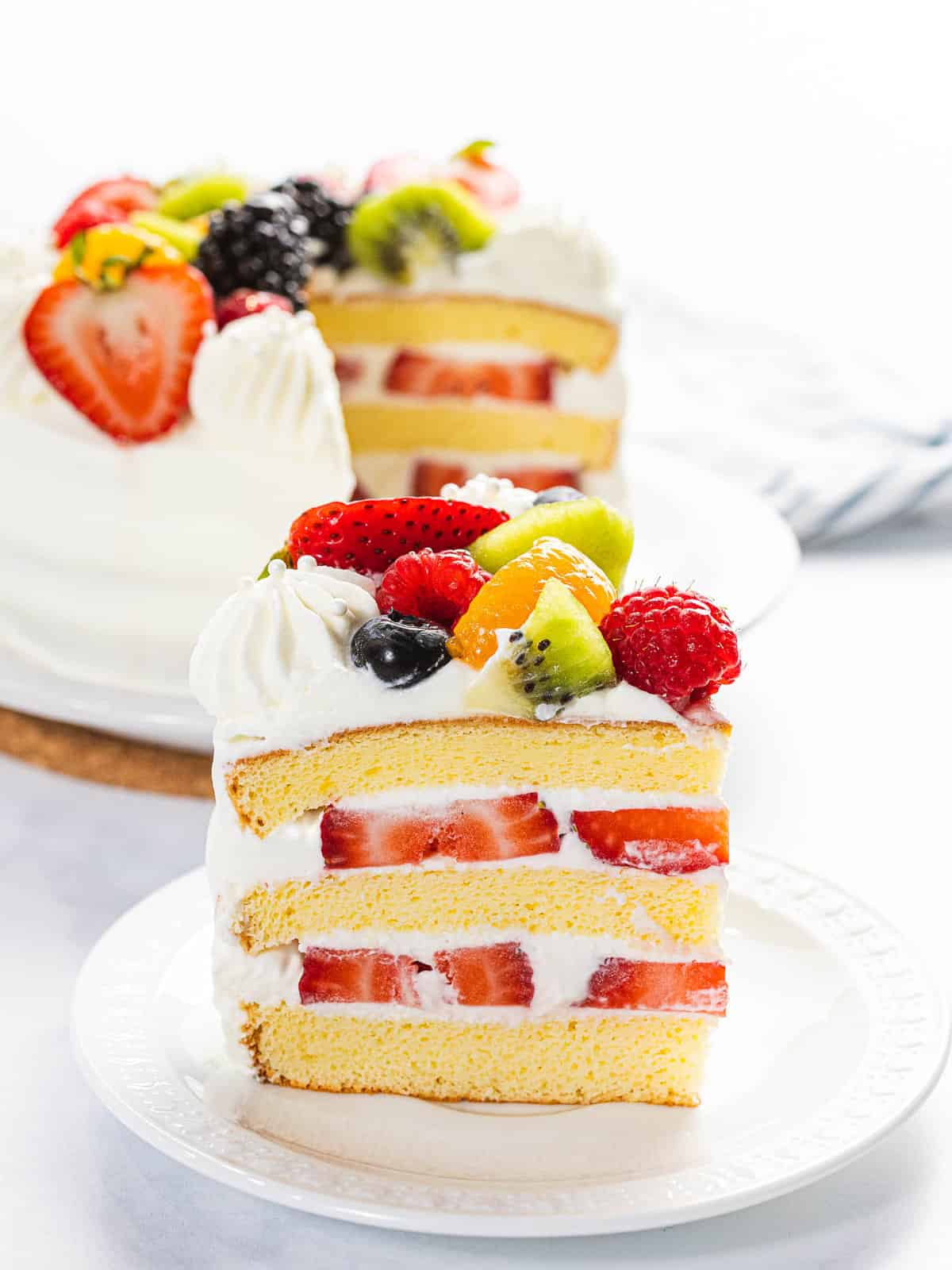Fresh fruit cake layered with sponge cake, whipped cream, and berries.