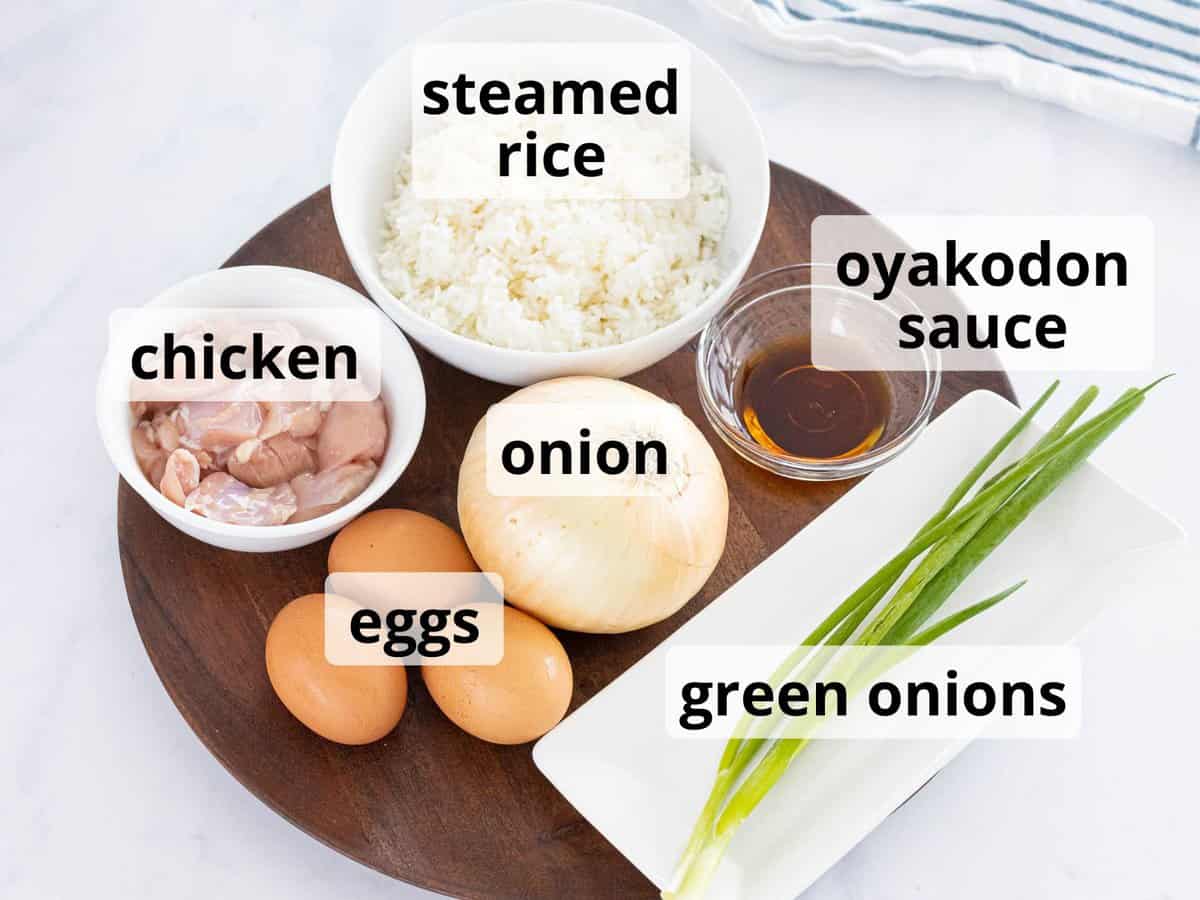 Ingredients for oyakodon including chicken, eggs, onions, and rice.