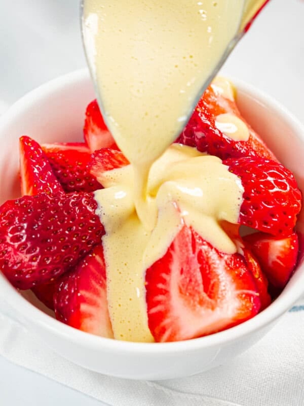 Zabaglione poured over a bowl of strawberries.