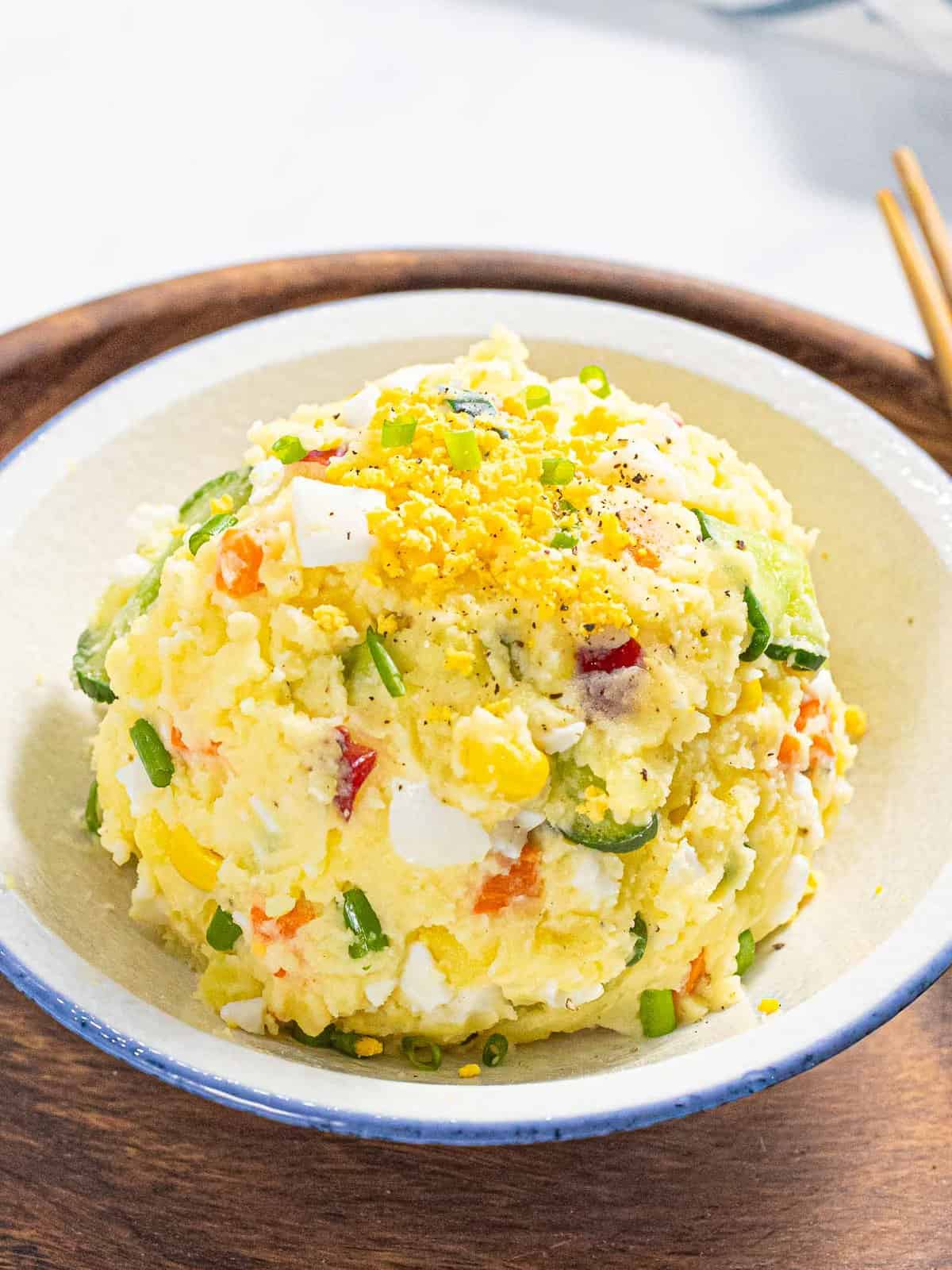 Korean potato salad with carrots, cucumber, and egg in a bowl.