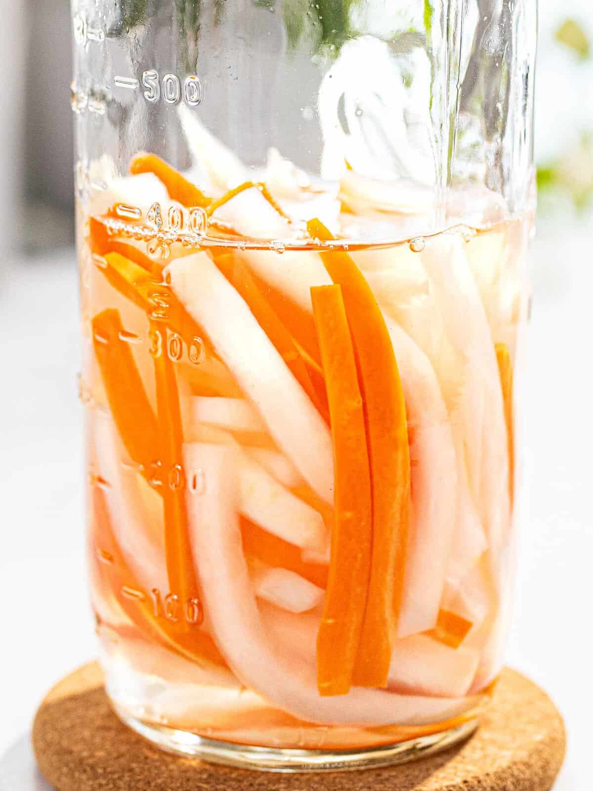 Vietnamese pickled carrots and daikon in a glass jar.