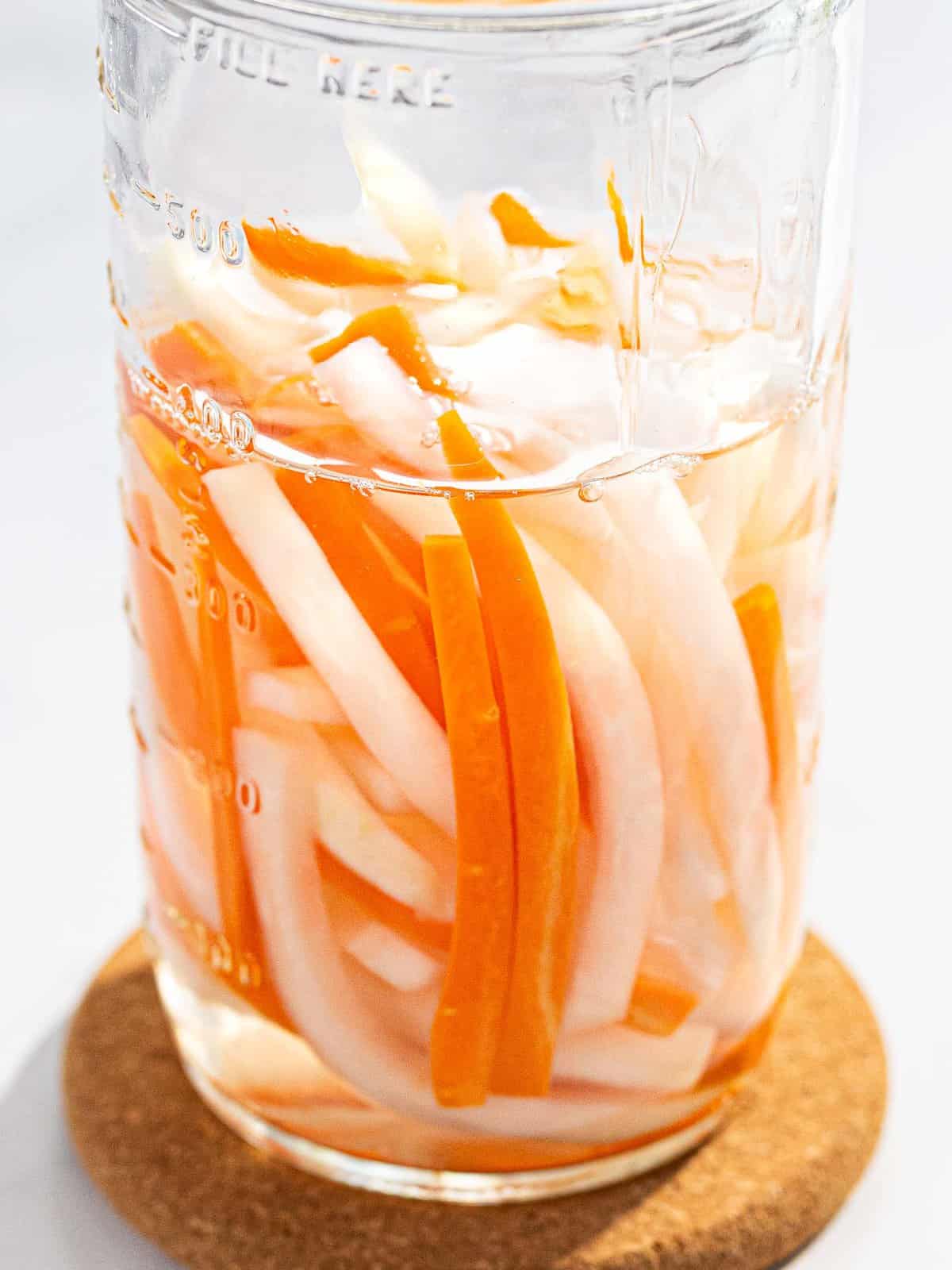 Vietnamese pickled carrots and daikon in a glass jar.